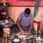🇮🇳 Inde : Un vendeur de rue déjeune tranquillement entouré de rats qui grimpent sur lui et sa nourriture, scène filmée sans réaction particulière.